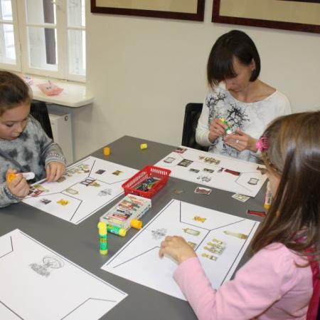 Uczestniczki  warsztatów projektują na szablonie wnętrza wybrane pokoje.