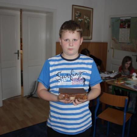 Uczestnik warsztatów prezentuje wykonaną przez siebie miniaturową walizkę