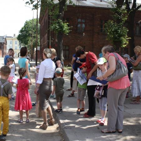 Uczestnicy letnich warsztatów na Księżym Młynie przed dawnymi domami pracowników fabryki.
