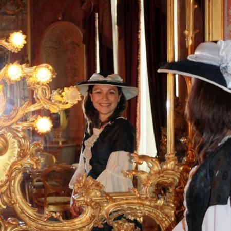 Zdjęcie przedstawia młodą kobietę uśmiechającą do siebie w lustrze.