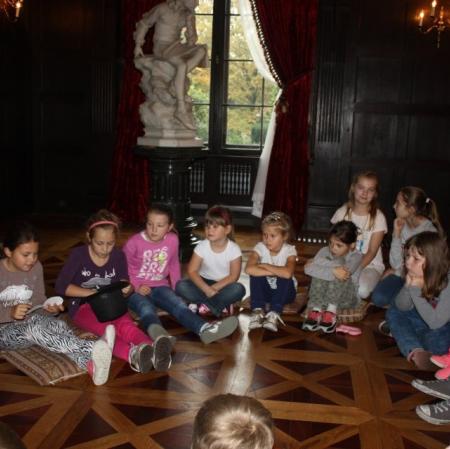 Sala balowa. Uczestnicy warsztatów siedzą w kręgu. Losują cytaty z XIX wiecznych poradników.