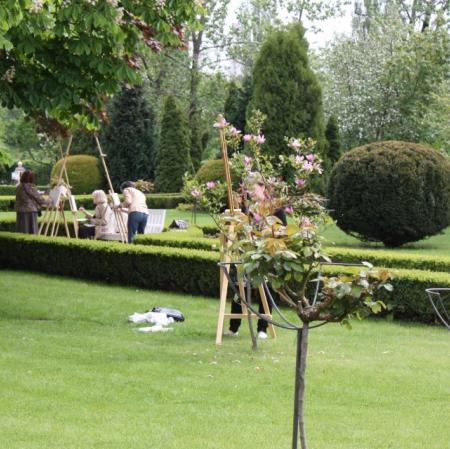 Warsztaty plenerowe w ogrodzie - uczestnicy przy sztalugach.