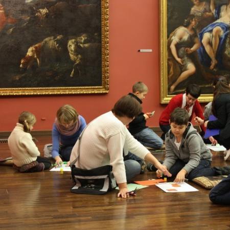 Uczestnicy podczas rodzinnych warsztatów w Galerii Sztuki Dawnej tworzą kopie obrazów obecnych w galerii.