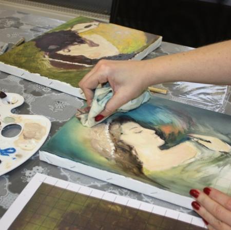 Zbliżenie na dłonie uczestniczki oraz powstającą prace malarską.