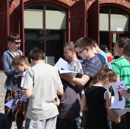 Uczniowie podczas warsztatów przed budynkiem dawnej straży pożarowej.