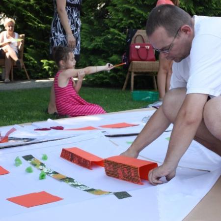 Uczestnik warsztatów wykonuje element makiety - domy.