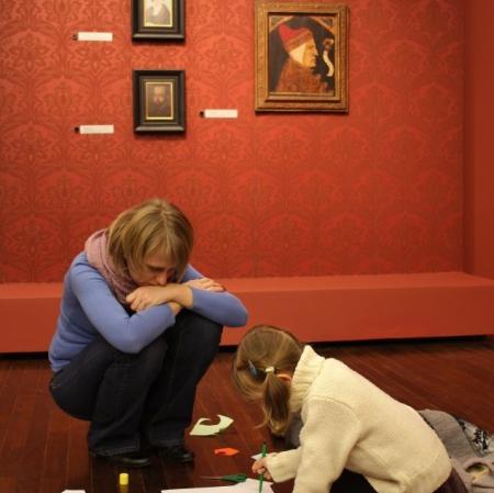 Uczestnicy podczas rodzinnych warsztatów w Galerii Sztuki Dawnej tworzą kopie obrazów obecnych w galerii.