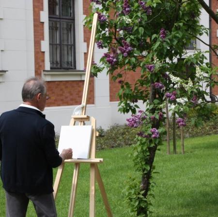 Warsztaty plenerowe w ogrodzie - uczestnik zajęć przy sztaludze.