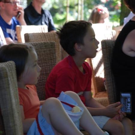 Zapatrzeni najmłodsi widzowie teatralnego przedstawienia "Hamlet" Williama Szekspira w adaptacji Adama Walnego pod altaną Muzeum Pałac Herbsta.