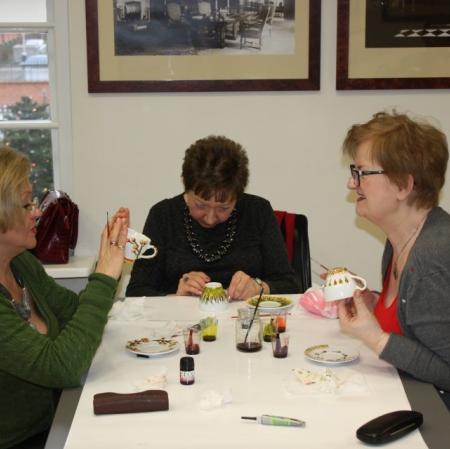 Uczestniczki warsztatów malują na porcelanowych filiżankach.