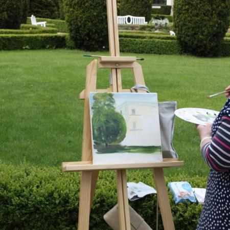 Warsztaty plenerowe w ogrodzie - uczestniczka zajęć przy sztaludze.