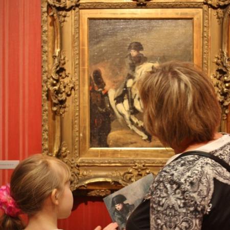 Uczestnicy podczas rodzinnych warsztatów w Galerii Sztuki Dawnej przed obrazem Piotra Michałowskiego "Napoleon".