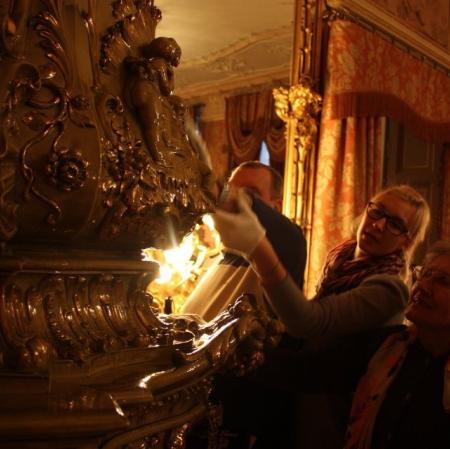 Salon lustrzany. Uczestnicy warsztatów przed piecem.