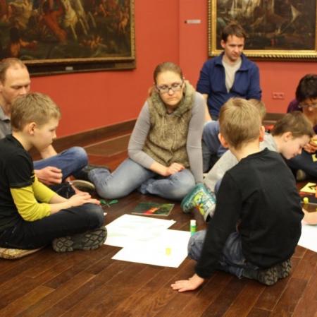 Uczestnicy podczas rodzinnych warsztatów w Galerii Sztuki Dawnej tworzą kopie obrazów obecnych w galerii.