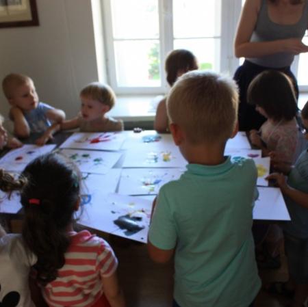 Uczestnicy warsztatów Pałacowa menażeria w sali edukacyjnej oglądają galerię wykonanych przez siebie prac przedstawiające zwierzaki-cudaki.