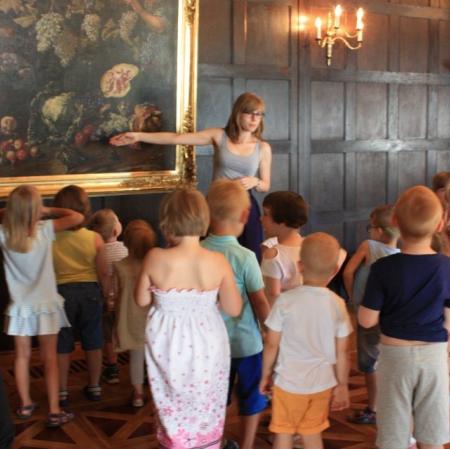 Przedszkolaki na warsztatach Pałacowa menażeria na sali balowej w Muzeum Pałac Herbsta szukają zwierzaków. Na obrazie  Giovanniego Battisty Ruoppolo "Alegoria zbiorów jesiennych" dzieci znalazły żółwia.