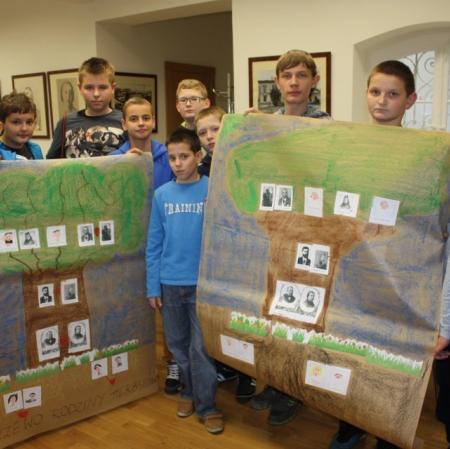 Prezentacja dwóch prac wykonanych  podczas warsztatów "Drzewo pokoleń" - zdjęcie grupowe uczestników.