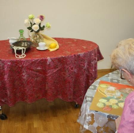 Uczestniczka warsztatów przed ustawioną martwą nuturą.