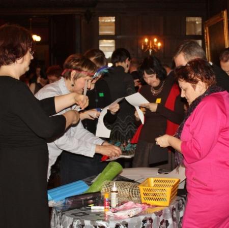 Uczestnicy karnawału wykonują swoje własne maski za pomocą przygotowanych materiałów na sali balowej w Pałacu Herbsta.