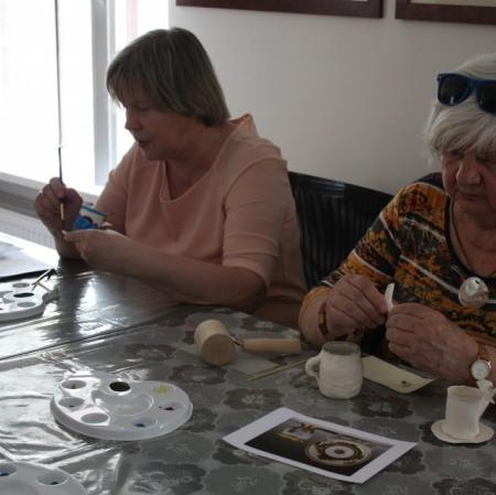 Uczestniczki warsztatów dekorują filiżanki w stylu empirowym
