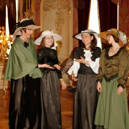 Zdjęcie przedstawia cztery kobiety w kapeluszach stojących obok siebie.