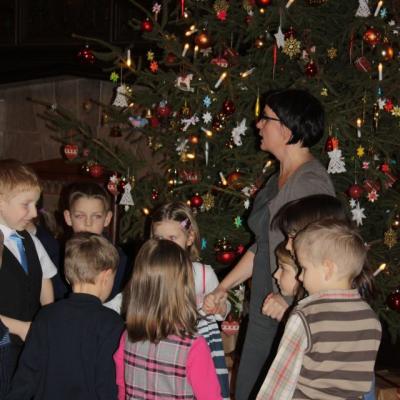 Zdjęcie: kilkoro dzieci stoi przed świąteczne ozdobiona choinką