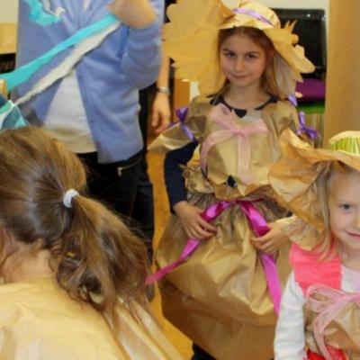 Kilkoro dzieci w strojach wykonanych z papieru pakowego