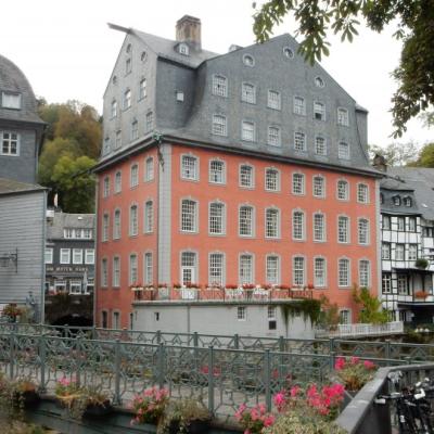 W centrum duży budynek mieszkalny o czterech dolnych kondygnacjach z czerwonej cegły