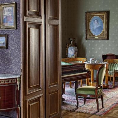 Fragment salonu rodzinnego widziany przez otwarte drzwi sypialni pana domu