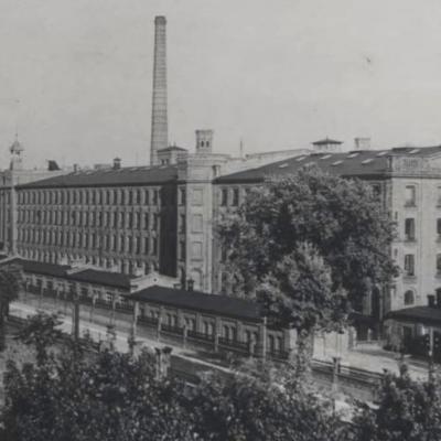 Czarno-biała fotografia przedstawiająca duży gmach fabryki