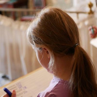 Dwoje dzieci w pokoju panieńskim, w rękach trzymają kartki na podkładkach