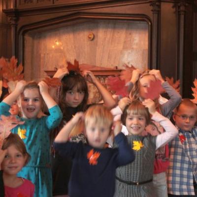 Zdjęcie: liczna grupa dzieci stoi z podniesionymi rękami.