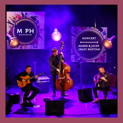 Zdjęcie trzech muzyków występujących na scenie w nastrojowym, fioletowym oświetleniu