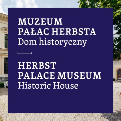 The image features a large navy blue rectangular overlay with white text in Polish and English. The upper part reads: "MUZEUM PAŁAC HERBSTA Dom historyczny," with a thin horizontal line below. The lower part contains the translation: "HERBST PALACE MUSEUM Historic House." In the background, a historic light-colored building with arched windows is partially visible, along with a cobblestone pathway, a white bench on the left, and a green tree in the upper right corner.